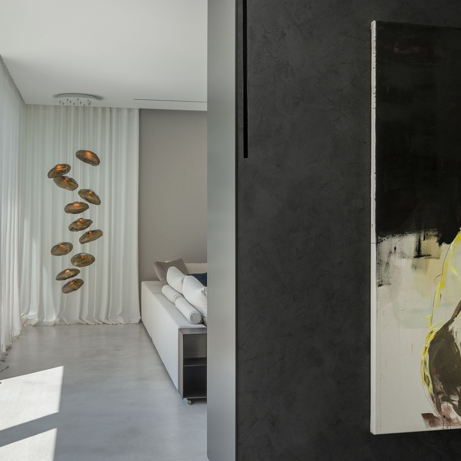 Sichtestrich und weiße Vorhaenge mit einer Pendelleuchte von Bocci